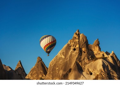 Balloons over tuff houses in a valley in Cappadocia.Balloons in the sky in Cappadocia in Turkey. Flying colorful multicolored balloons in the sky