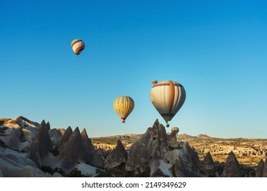 Balloons over tuff houses in a valley in Cappadocia.Balloons in the sky in Cappadocia in Turkey. Flying colorful multicolored balloons in the sky