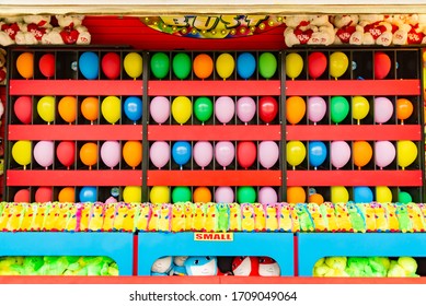 Balloons And Prizes At A Dart Throwing Game Booth At A Carnival, Fair, Or Amusement Park In America