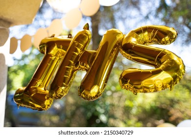 Balloons In The Shape Of The Letters IHS, Referring To The Sacrament Of First Holy Communion. In The Background, An Outdoor Party For Children. IHS 