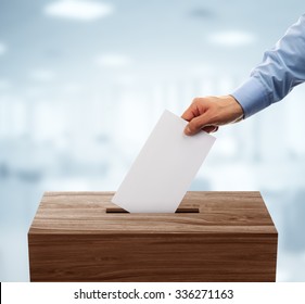 Ballot box with person casting vote on blank voting slip - Shutterstock ID 336271163
