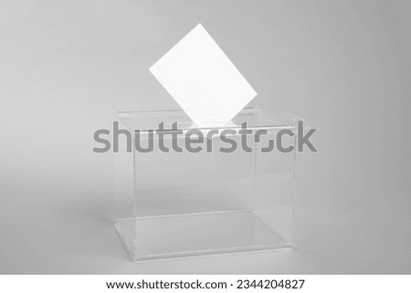 Ballot box with vote on light grey background. Election time