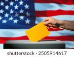 Ballot envelope for the 2024 presidential election in the USA. Ballot envelope in orange over ballot box. Flag of the United States of America in background. Choice between Democrats and Republicans.