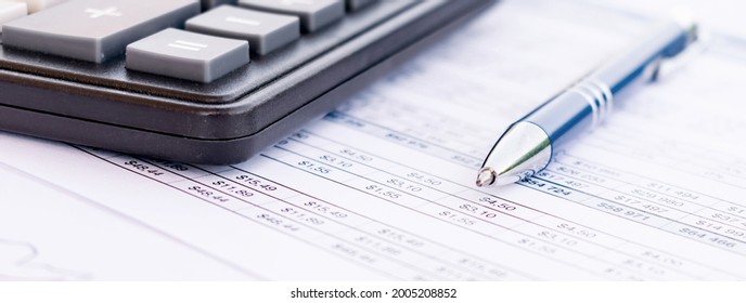 Ballpoint Ink Pen And Calculator On A Financial Spreadsheet Statement With Columns Of Numbers For An Accounting Budget Finance Reconciliation