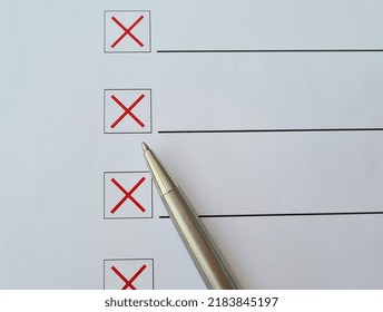 Ballpoint Pen Crosses Off Checklist Items With A Red X On White Paper. Test And Failure Concept