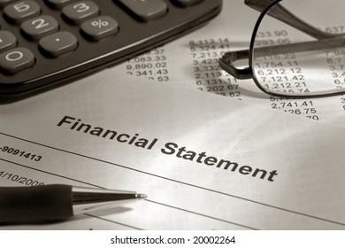 Ballpoint Pen On Brokerage Financial Account Statement With Calculator And Glasses