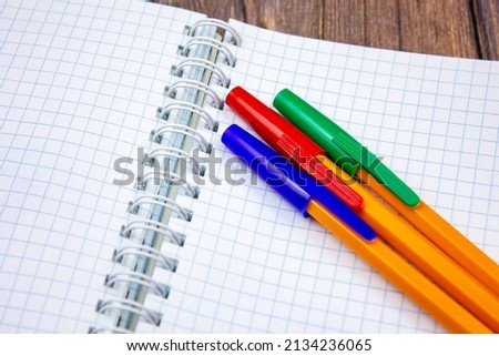 The Ballpoint pens. Choice of handles. Colored pens. Ink pens for writing.Pens lie on the notepad page.Office stationery concept.