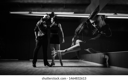 Ballroom dancers. The guy with the girl is engaged in ballroom dancing. Ballroom dancing. Dancing. The guy with the girl dancing in a dark room. Black and white.