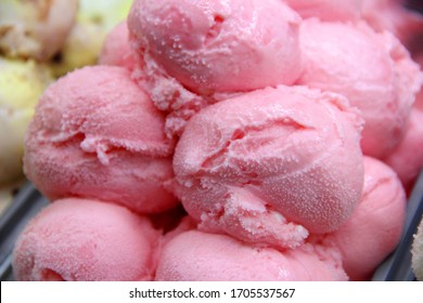 balls of ice cream in a metal container, close-up. raspberry ice cream balls in a container, selective focus