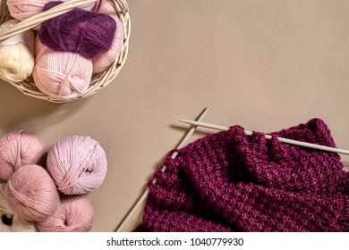 Balls Of Merino Wool Yarn, Knitting On Knitting Needles On A Beige Surface. Top View