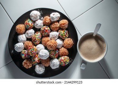 Balls Of Sweet Bread On A Black Plate With A Cup Of Hot Coffee Chocolate Moka Over A White Table And A Black Background, Horizontal Lay Flat Top View Overhead Shot
