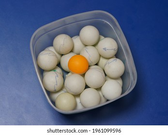 Balls for table tennis in the box lie on the table. Almost all of them are white. One of them is unique red color. Sportive theme. When you are not like everyone else. Closeup image - Powered by Shutterstock