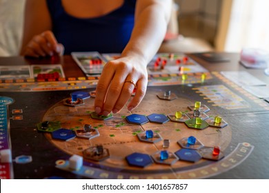 Balogunyom / Hungary -04.28.2019: Woman player placing pieces of the board game on the board while playing Terraforming Mars strategy game