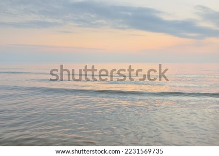 Baltic sea after the rain. Dramatic sunset sky, glowing pink and golden storm clouds. Picturesque panoramic scenery. Nature, environment, fickle weather, cyclone