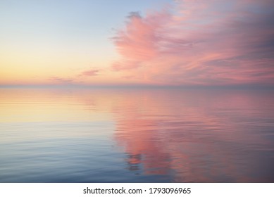 Baltic sea after the rain at sunset. Dramatic sky with glowing  pink clouds, symmetry reflections in the water. Abstract natural pattern, texture, background, concept art - Shutterstock ID 1793096965