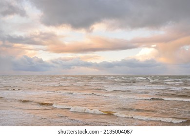 Baltic sea after the storm. Dramatic sky, glowing clouds, soft sunlight. Waves, splashing water. Picturesque scenery, seascape, nature. Panoramic view