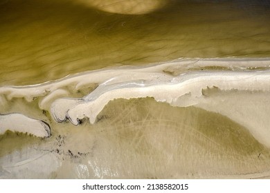 Baltic Sea, bird's eye view from a drone flying over an empty beautiful beach. Small waves breaking on the sandy beach.