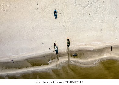 Baltic Sea, bird's eye view from a drone flying over an empty beautiful beach. Small waves breaking on the sandy beach.