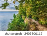 The Baltic Sea coastal landscape with autumn foliage of seaside forest, view from a trail on top of a cliff in Gdynia, Poland.