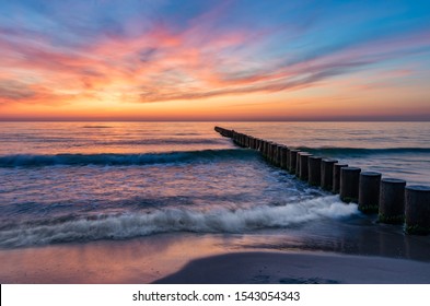 Baltic Sea Seascape At Sunset, Poland, Wooden Breakwater And Waves