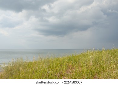 Baltic Sea Shore After The Rain. Sand Dunes, Dune Grass. Dramatic Sunset Sky, Glowing Storm Clouds, Wind. Picturesque Panoramic Scenery. Nature, Environment, Fickle Weather, Cyclone