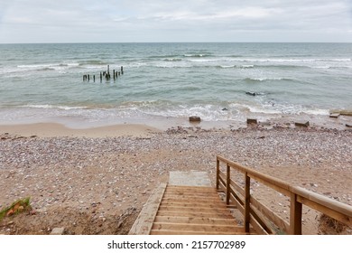 Baltic Sea Shore (beach) After The Rain And Storm. Modern Wooden Walkway (boardwalk). Waves And Water Splashes. Nature, Ecology, Eco Tourism, Hiking, Recreation Concepts