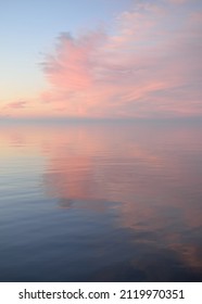 Baltic sea at sunset. Clear sky, blue and pink glowing clouds, soft golden sunlight. Water surface texture. Picturesque dreamlike seascape, cloudscape, nature. Panoramic view