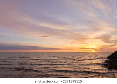 Baltic sea at sunset. Dramatic sky, blue and pink glowing clouds, soft golden sunlight, midnight sun. Picturesque dreamlike seascape, cloudscape, nature. Panoramic view