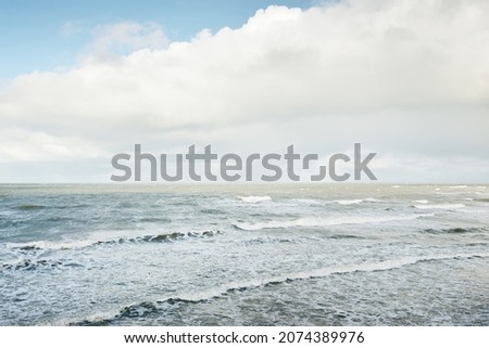 Baltic sea under dramatic sunset clouds after the storm. Waves, splashing water. Epic seascape. Cyclone, gale, storm, rough weather, meteorology, ecology, climate change, natural phenomenon