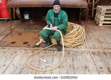 Baltic Sea-09.26.2013.Old sailor repairs fishing gear on ship deck
