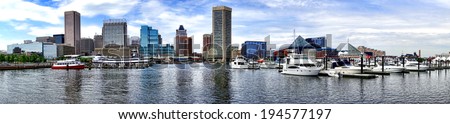 Baltimore Inner Harbor boat marina with shopping centers near National Aquarium and downtown business district buildings in scenic skyline of the Maryland city in wide cityscape panoramic view