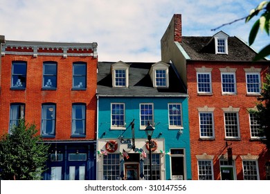 Baltimore, Maryland - July 22, 2013:  18th and 19th century brick buildings lining the historic Thames Street waterfront now house trendy shops, pubs, and restaurants at Fells Point