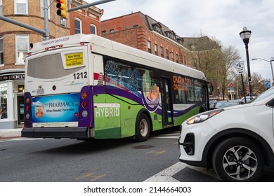 Baltimore, Maryland US - April 9, 2022:  Charm City Circulator Purple Route Hybrid Vehicle Bus Public Transportation Passes Intersection In Federal Hill Neighborhood 