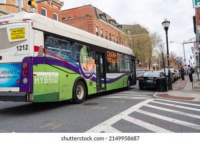 Baltimore, Maryland US - April 9, 2022: Yellow Sign On Back Of Charm City Circulator Reads New Hiring Commercial Drivers Licensed Drivers And Mechanics As It Crosses An Intersection Along Light St