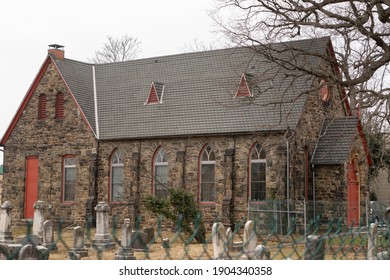 Baltimore, Maryland US - January 08, 2021: Nonprofit Affordable Housing Developer Episcopal Housing Corporation Headquarters Stone Building Bordering A Cemetary On Roland Avenue In Hamden, MD.