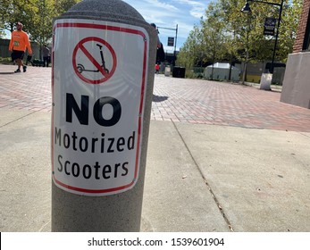 Baltimore, Maryland / US - October 19, 2019 - A Illegal Warning Sign Sticker Placed On Concrete Traffic Barrier Reads No Motorized Scooters Against Electric Riders On Pedestrian Ravens Walk Downtown