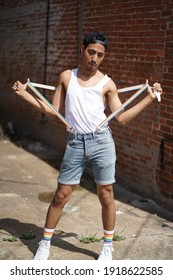 Baltimore, Maryland - USA - June 15, 2019: Gay Pride Downtown Baltimore. Portrait Of A Young Latino Brown Male Posing With Short, White T-shirt And Rainbow Suspenders In An Alley.