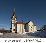 Bamble Church, large wooden church buildt in 1845. Winter, snow, sunshine and blue sky. Side view. Horizontal image.