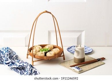 Bamboo Dish with Chinese Steamed Ravioli Jiaozi Shuijiao, on White Background. Copy Space for text or Advertisement