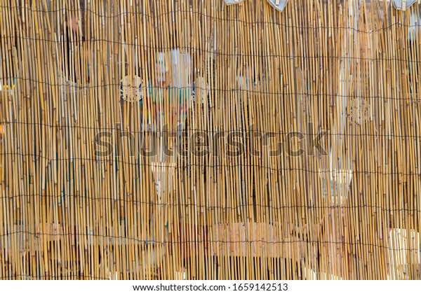 Bamboo divider screen in bright sunlight at an\
outdoor market
