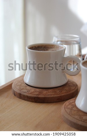 Bamboo on wooden tray, white porcelain coffee cup with patterned cup bottom