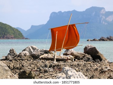 Bamboo Raft With Sails Stranded On Rocks By The Sea In The Gulf Of Thailand.