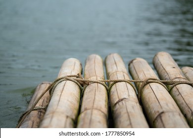 Bamboo Rafting Stacked Which Is Binding With Rope Line, It's Floating On The Lake Water. Journey Or Adventure Activity. Transportation Object. Selective Focus On The Rope Surface.