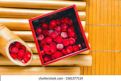 Bamboo sticks and bamboo napkin with red coral beads. Traditional bamboo pad with parts of dry bamboo