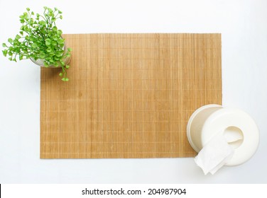 Bamboo Table Mat With A Small Plant And A Tissue Box