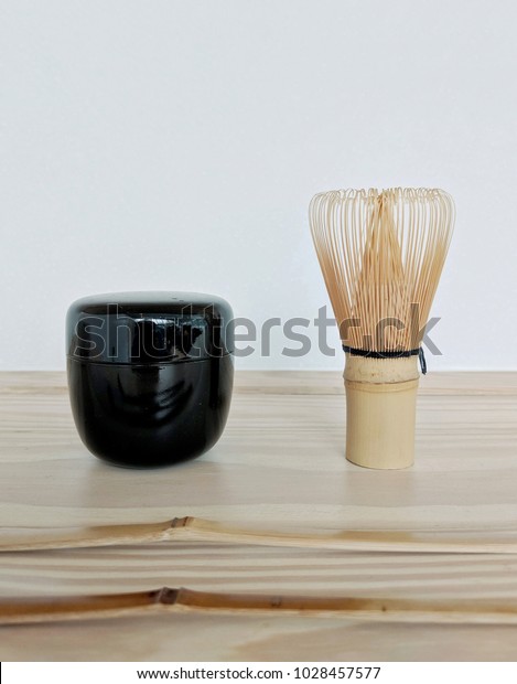 Bamboo Tea Whisk and a black shiny\
small matcha tea caddy. the bamboo tea whisk is carved from a\
single piece of bamboo for japanese Matcha Mixer Tea\
Ceremony.