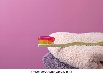 Bamboo Toothbrush, Cotton Towels. Pink Background. Biodegradable Personal Hygiene Products. There Is No Plastic Concept. Place For Text