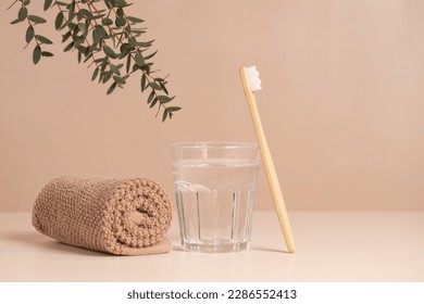 Bamboo toothbrush, towel and a glass of water. Eco-friendly items. Oral care. Biodegradable personal care products.