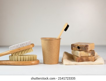 Bamboo Toothbrush In A Transparent Glass, Homemade Organic Plant-based Soap, Bamboo Massage Brush With Natural Bristles On A Green And Beige Terry Towels. Eco-friendly, Biodegradable, Zero Waste.