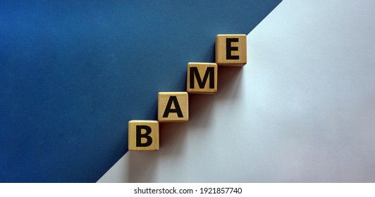 BAME symbol. Abbreviation BAME, black, asian and minority ethnic on wooden cubes. Beautiful white and blue background. Copy space. Business and BAME, black, asian and minority ethnic concept.